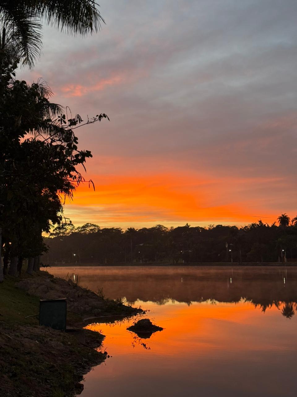 C&eacute;u alaranjado sobre a lagoa antes do evento